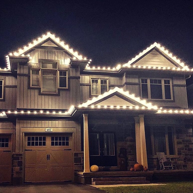 Craftsman home with warm white C9 Christmas lights along multiple gables and peaks